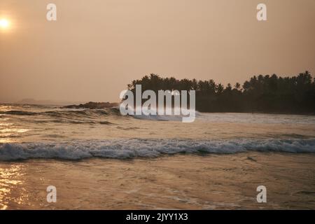 Sunset on the ocean with big waves in Sri Lanka Stock Photo