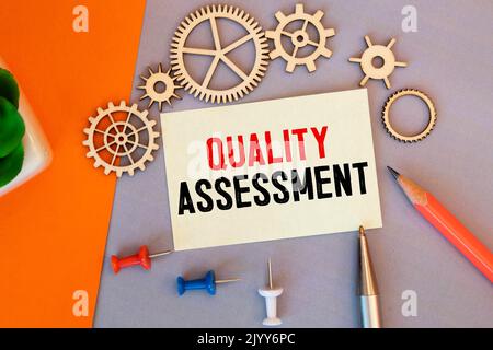 The word quality assessment written on a notebook on business office desktop. Stock Photo