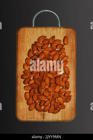 Almonds on a wooden board. Isolated on black background. Top view. Stock Photo