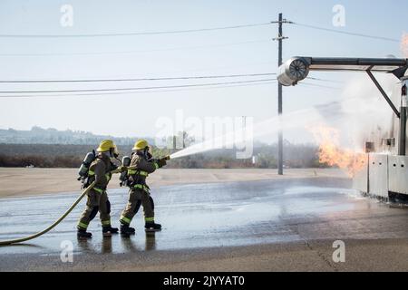 U.S. Marines with Aircraft Rescue and Fire Fighting, Headquarters and Headquarters Squadron, Marine Corps Air Station Miramar, spray water on flames coming from a mobile burn unit during an aircraft mishap full scale exercise on MCAS Miramar, San Diego, California, Aug. 17, 2022. This emergency response exercise was conducted for first responders in order to maintain proficiency and preparedness for potential real-world threats and hazards on the installation. (U.S. Marine Corps photo by Lance Cpl. Jose S. GuerreroDeLeon) Stock Photo