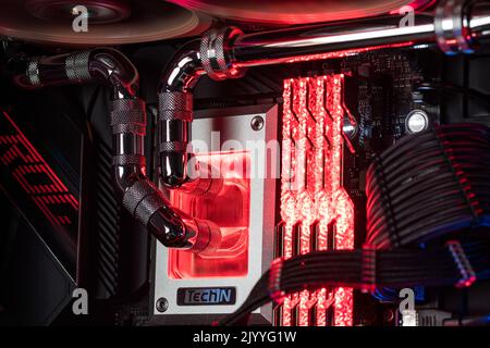 Prague, Czech Republic - 21 July 2021: Close-up of high performance Desktop PC and water cooling system with multicolored LED RGB light show status on Stock Photo