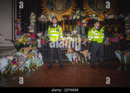 LONDON, ENGLAND - SEPTEMBER 08: Police officers stand amongst floral tributes left outside Buckingham Palace in central London, following the announcement of the death of Queen Elizabeth II,Credit: Horst A. Friedrichs Alamy Live News Stock Photo