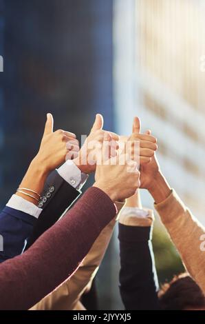 Thumbs up all around. a group of businesspeoples hands showing thumbs up. Stock Photo