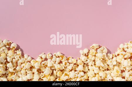Popcorn placed on pink background with copy space. Viewed from directly above. Stock Photo