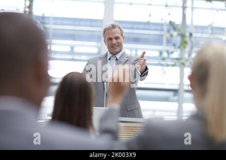 Thats a great comment. A handsome senior executive seeking his colleagues input while delivering a speech at a seminar. Stock Photo
