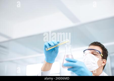 The expert at mixing chemicals. Low angle shot of a chemist mixing chemicals. Stock Photo