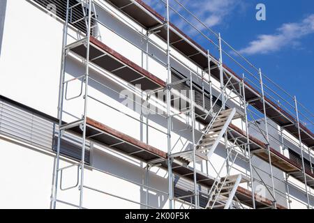Scaffolding, Painting work: Scaffolding on a new apartment building with white facade painting Stock Photo