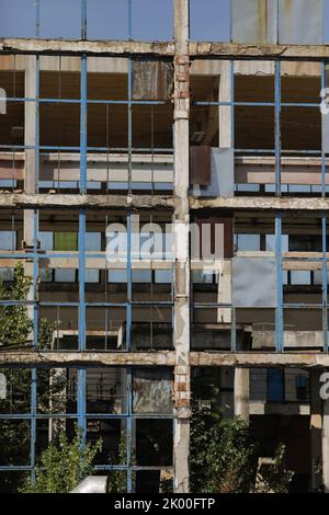 Broken walls and windows in an abandoned industrial building. Stock Photo