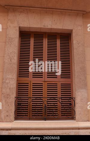 Windows with wooden shutters and an iron railing Stock Photo