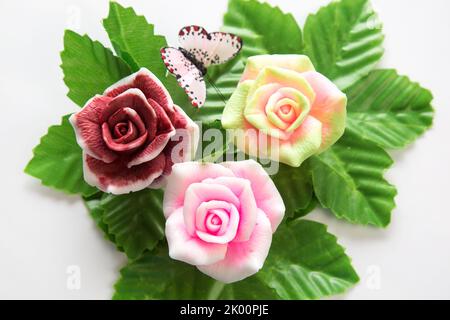 Bright handmade soap roses on artificial leaves, close-up. Stock Photo