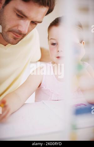 She always does her homework. a little girl doing her homework. Stock Photo