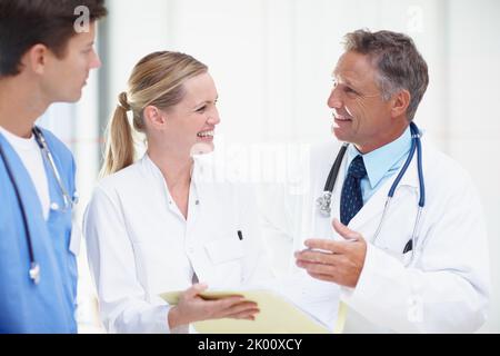 Sharing ideas on their craft. Three medical professionals sharing advice and ideas. Stock Photo