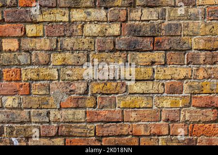 A red, yellow and brown old brick wall. Stock Photo