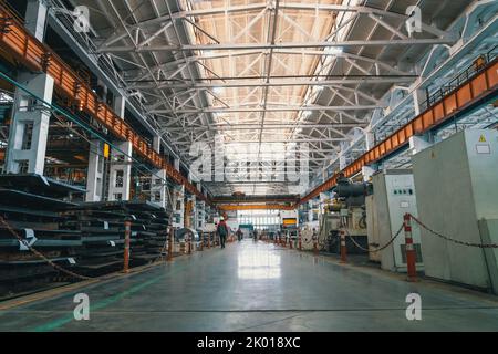Big industrial factory interior. Workers and technique equipment in workshop. Stock Photo