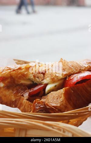 Homemade croissant filled with tomatoes, eggs and spices. Breakfast in french caffee Macaronnerle in Heidelberg. Closeup. Side View, Macro Stock Photo