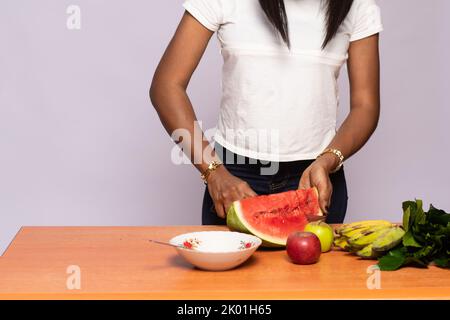 young black lady preparing mixed fruit salad Stock Photo