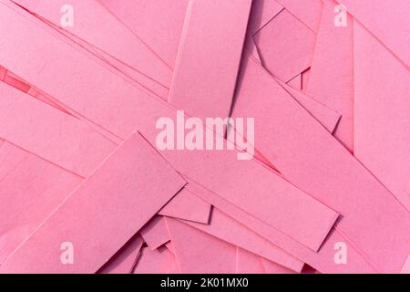 Pink paper texture background made from cut out strips of a recycled cardboard sheets stacked in a pile to give a natural design patten effect, stock Stock Photo