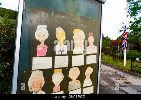 Balmoral, Scotland, UK. 9th September 2022.  Noticeboard outside Crathie Primary School with hand drawn portraits dedicated to the Platinum Jubilee of Queen Elizabeth II with Union Jack at half mast.  Iain Masterton/Alamy Live News Stock Photo