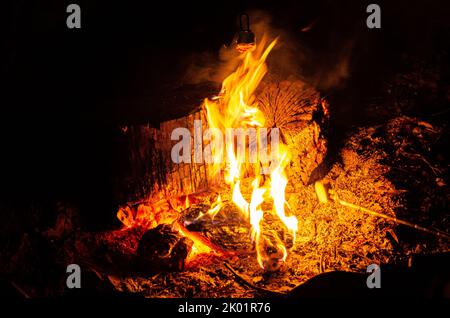 Logs burning in a campfire in a fire pit. Stock Photo