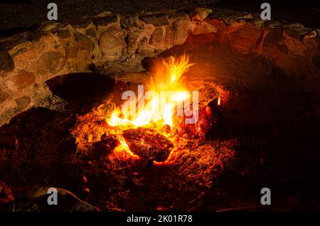 Logs burning in a campfire in a fire pit. Stock Photo