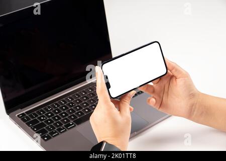 Modern phone mock up, office worker holding modern phone mock up. Close up over shoulder view of woman watching, looking, video calling. Stock Photo