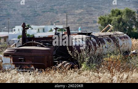 Old broken and rusty vehicles near Perivilos Beach, Santorini Stock Photo