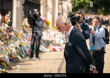 King Charles III looks at flowers outside Buckingham Palace, London after travelling from Balmoral following the death of Queen Elizabeth II on Thursday. Picture date: Friday September 9, 2022. Stock Photo