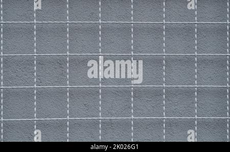 a metal grid and a gray wall behind it 2 Stock Photo