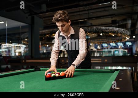Man putting billiard balls in triangle rack Stock Photo