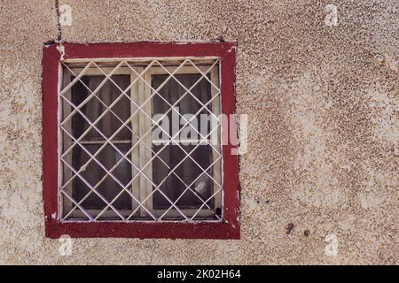 A white window, red painted frame and dirty wall, selective focus Stock Photo