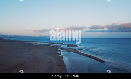 Blue colors sunset landscape at the beach with ocean and sky. Beautiful natural scenic place viewed from above. Concept of wonderful travel destination Stock Photo
