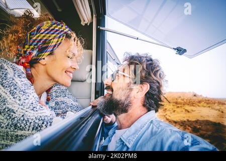 Happy adult tourist and traveler smile and have fun together inside and outside the camper car. Cheerful happy people enjoying travel and vacation. Mature couple in love and friendship portrait Stock Photo