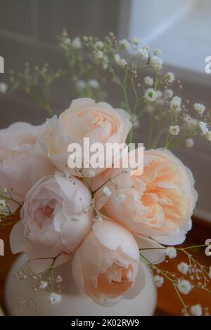 A vertical shot of orange English roses in a vase Stock Photo - Alamy