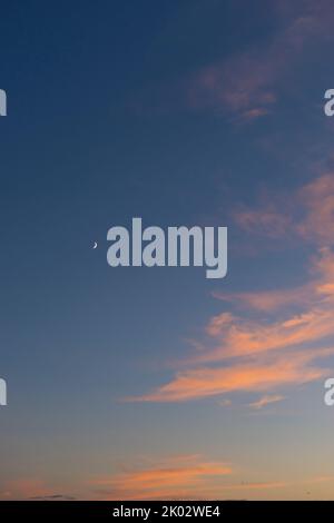 Clouds, red, orange, sky, crescent moon, evening glow Stock Photo