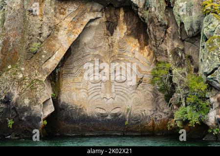 The view of Mine Bay Maori Rock Carvings by the water Stock Photo