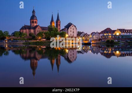 Germany, Hesse, Seligenstadt, Main, Mainufer, Benediktinerkloster, Einhard Basilika, evening lighting, skyline at blue hour, long exposure with the reflection in the river Stock Photo