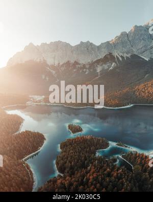 The mesmerizing aerial view of the Eibsee lake with evergreen trees in ...