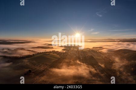 Germany, Thuringia, Koenigsee, Horba, village rises on a mountain from a sea of fog, overview, mountains, valleys, valley fog, sun, aerial photo, back light Stock Photo
