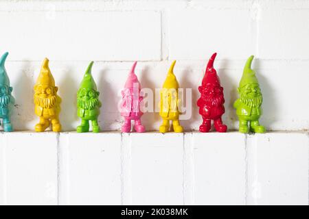 Colorful dwarfs on a white wall Stock Photo