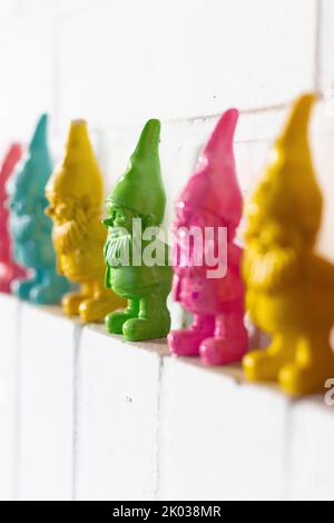 Colorful dwarfs on a white wall Stock Photo