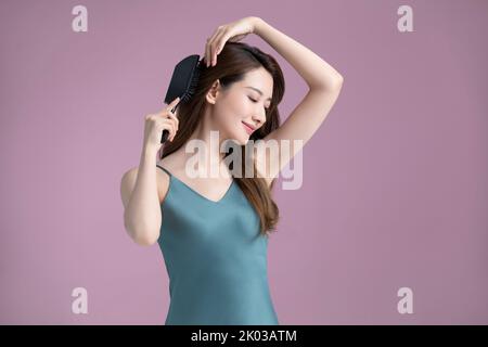 Beautiful young Chinese woman combing long hair Stock Photo