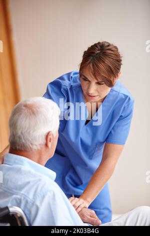 Checking up on her patient. a female nurse checking on her senior patient. Stock Photo