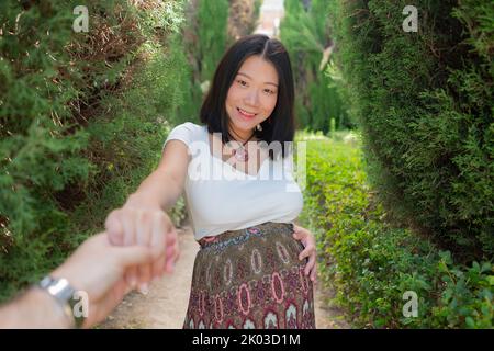 young happy and beautiful Asian Japanese woman posing outdoors happy and cheerful in the city pregnant showing her belly proud smiling in pregnancy an Stock Photo