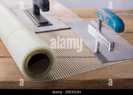 Fiberglass Reinforcing Plastering Mesh used for plaster work with rectangular trowel Stock Photo