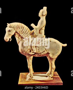 Tang Dynasty horse. white figurine, on an empty stomach, standing upright on a rectangular platform, with a strong horse shape, beige glaze all over the body, slightly light green. Although the horse is standing still, everything from its energetic face, strong legs and bones and strong bones and bones is vigorous and vivid, and the proportions of the shape and application are exquisite. Stock Photo