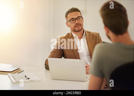 Getting some feedback. two businessmen in the boardroom. Stock Photo