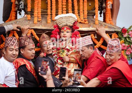 Nepal's Kumari (living goddess, C) is prepared to take part in the celebrations on the main of the Indra Jatra Festival at Hanuman Dhoka, Kathmandu Durbar Square (Basantapur Durbar Kshetra) in Kathmandu. The annual festival, named after Indra, the god of rain and heaven, is celebrated by worshipping, rejoicing, singing, dancing, and feasting in Kathmandu Valley to mark the end of the monsoon season. Indra, the living goddess Kumari and other deities are worshipped during the festival. Stock Photo