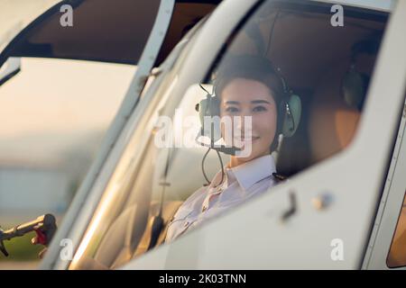 Chinese pilot sitting in helicopter cockpit Stock Photo