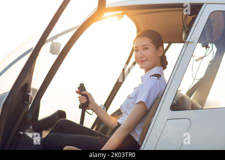 Chinese pilot sitting in helicopter cockpit Stock Photo