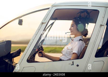 Chinese pilot sitting in helicopter cockpit Stock Photo